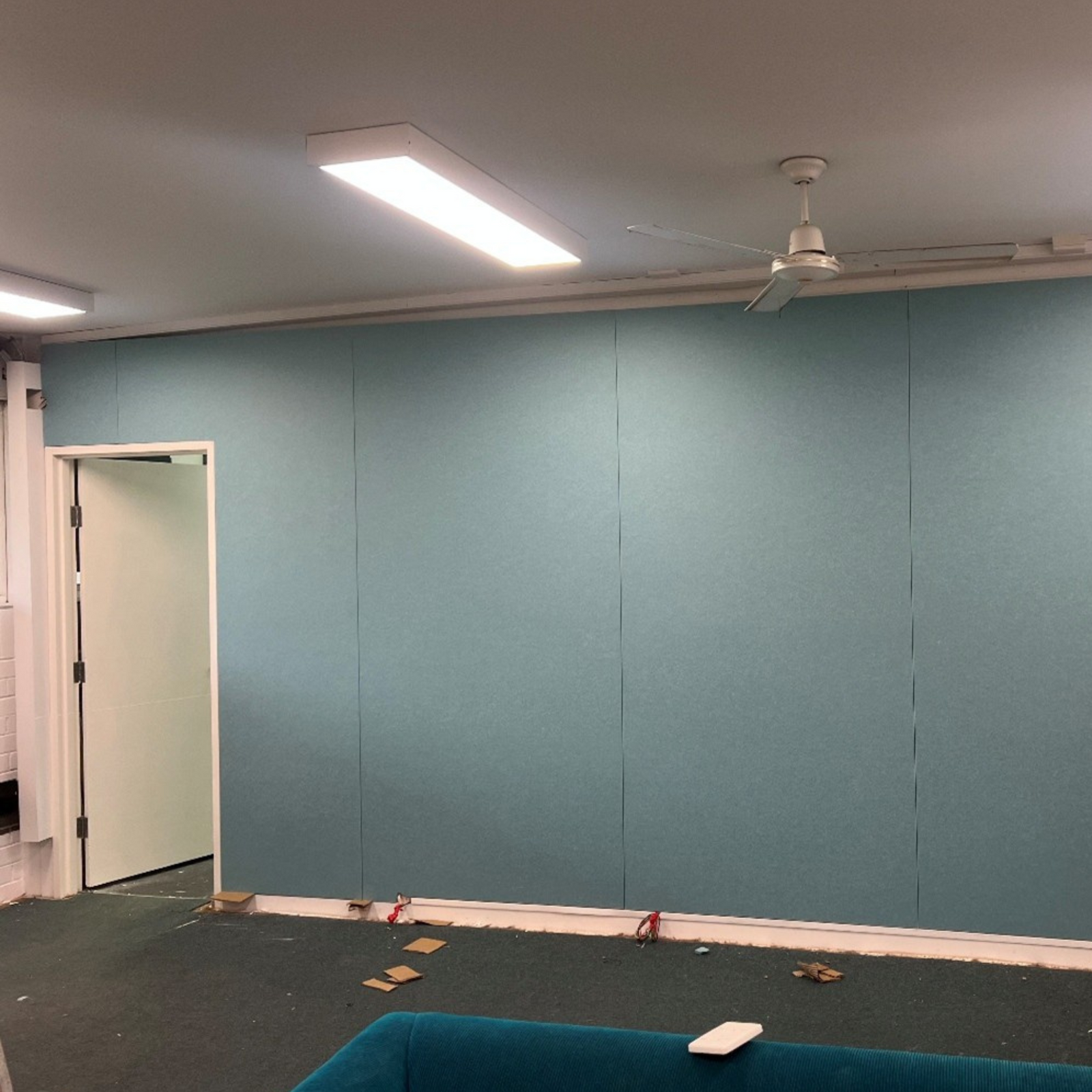 Close-up of blue-teal acoustic wall panels (Falling Water colour) installed at CathWest Innovation College.