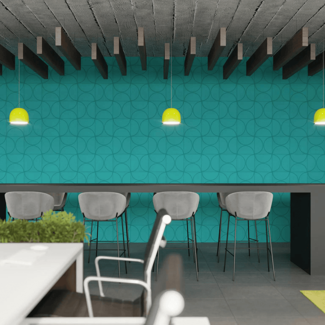 Modern workspace featuring turquoise acoustic tiles, stylish bar stools, and bright pendant lights, enhancing sound and design.
