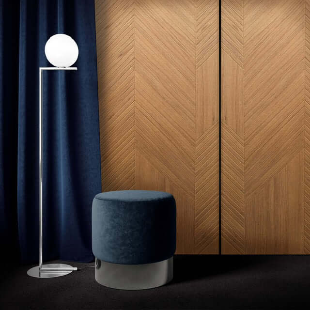 Stylish interior featuring Groove Timber Acoustic Panels with herringbone design, blue ottoman, and modern floor lamp.