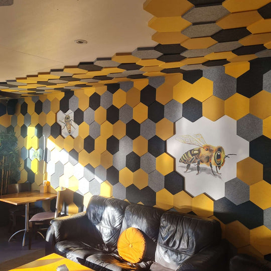 Interior view showcasing Cube™ Honeycomb Acoustic Tiles in yellow and gray, enhancing sound absorption and decor.