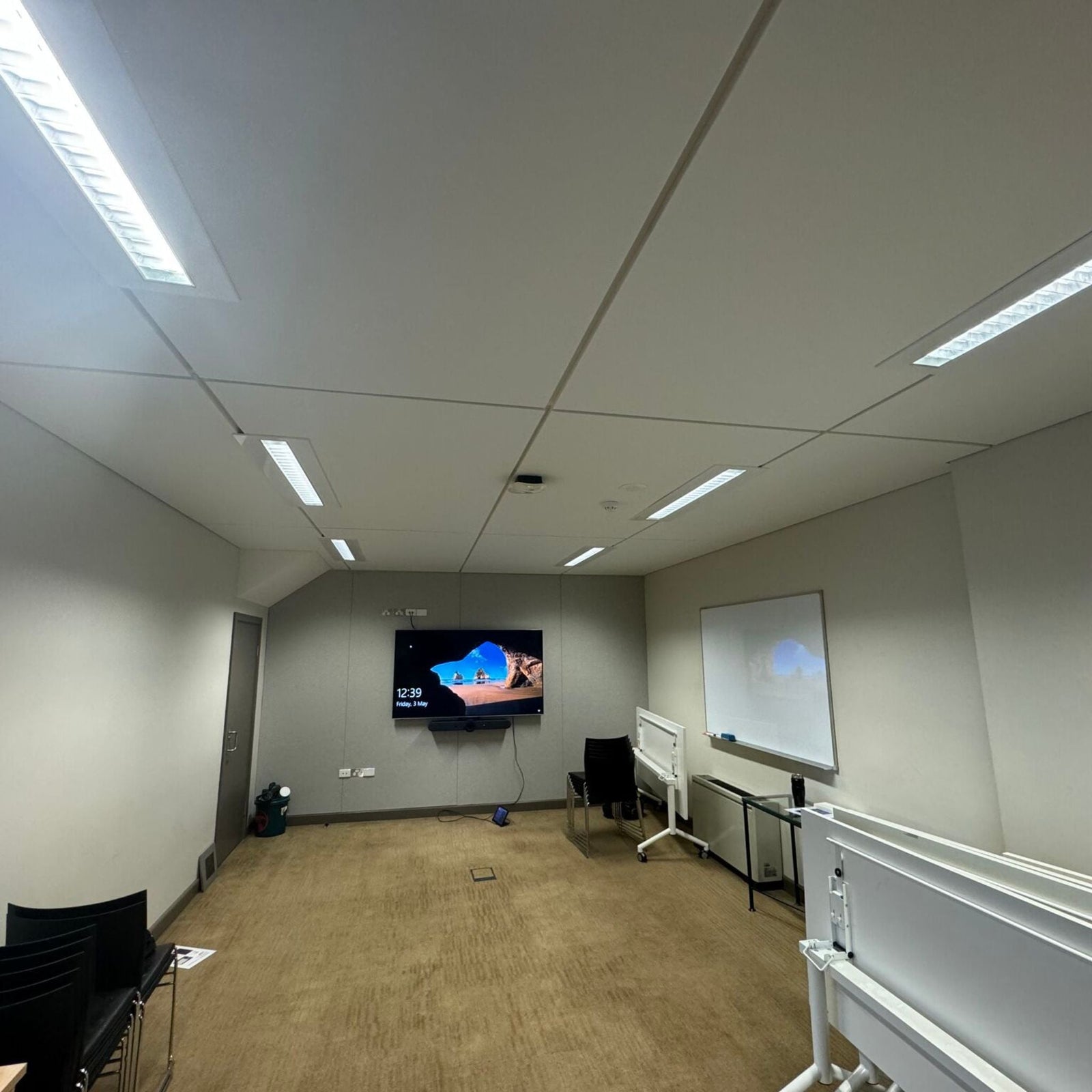 Interior of Bayside NSW Council chamber featuring modern ceiling and wall installations with digital displays.