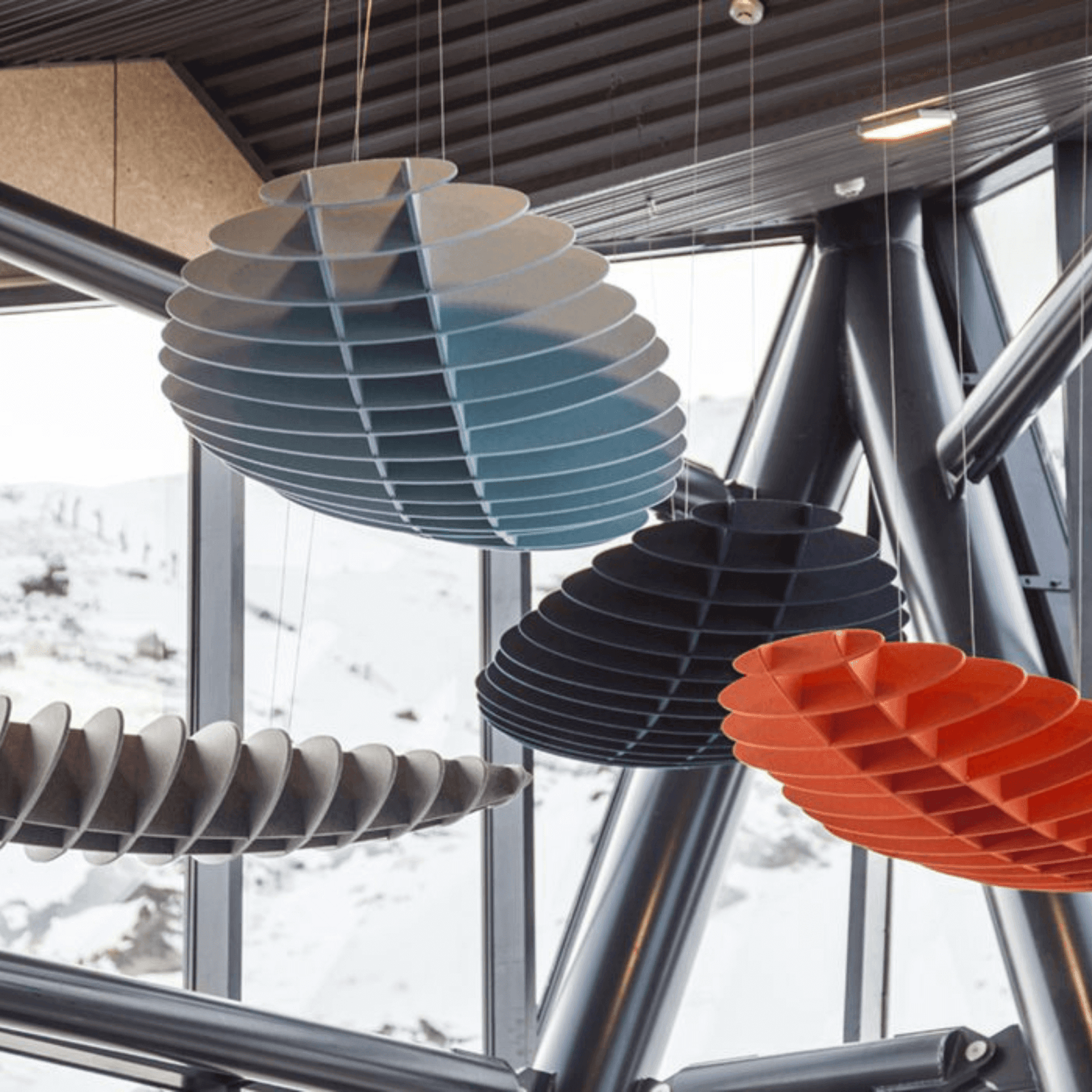 Colourful acoustic ceiling panels enhance sound absorption in a modern open space design.