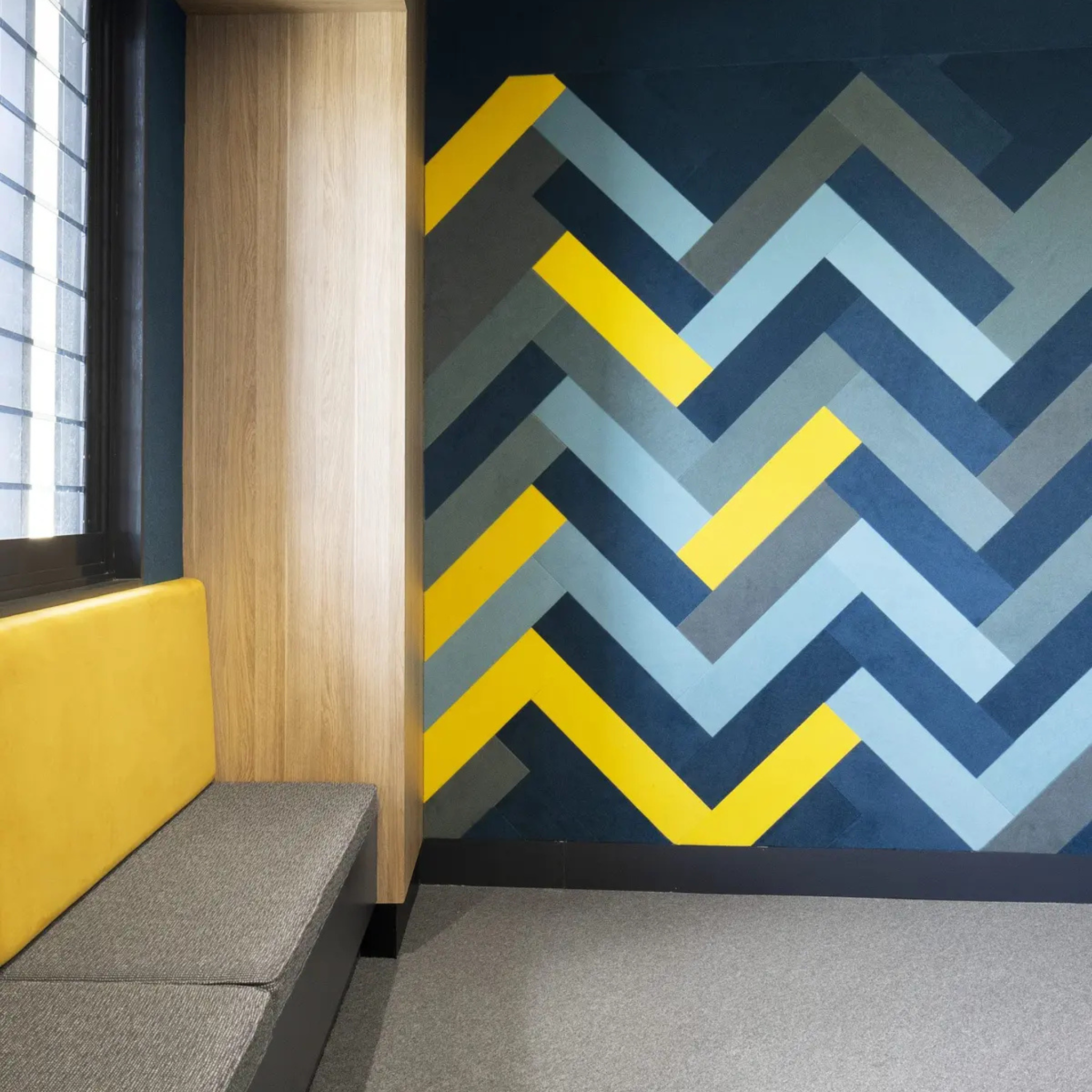 Stylish Autex Composition Peel n Stick Tiles in a chevron pattern, enhancing sound absorption in a modern workspace.