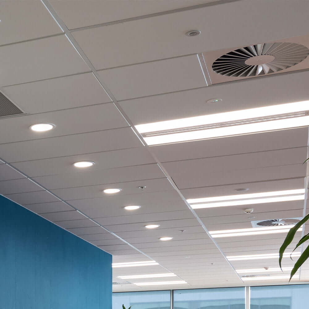 Modern acoustic ceiling tiles with recessed lighting, enhancing sound absorption and aesthetics in commercial space.