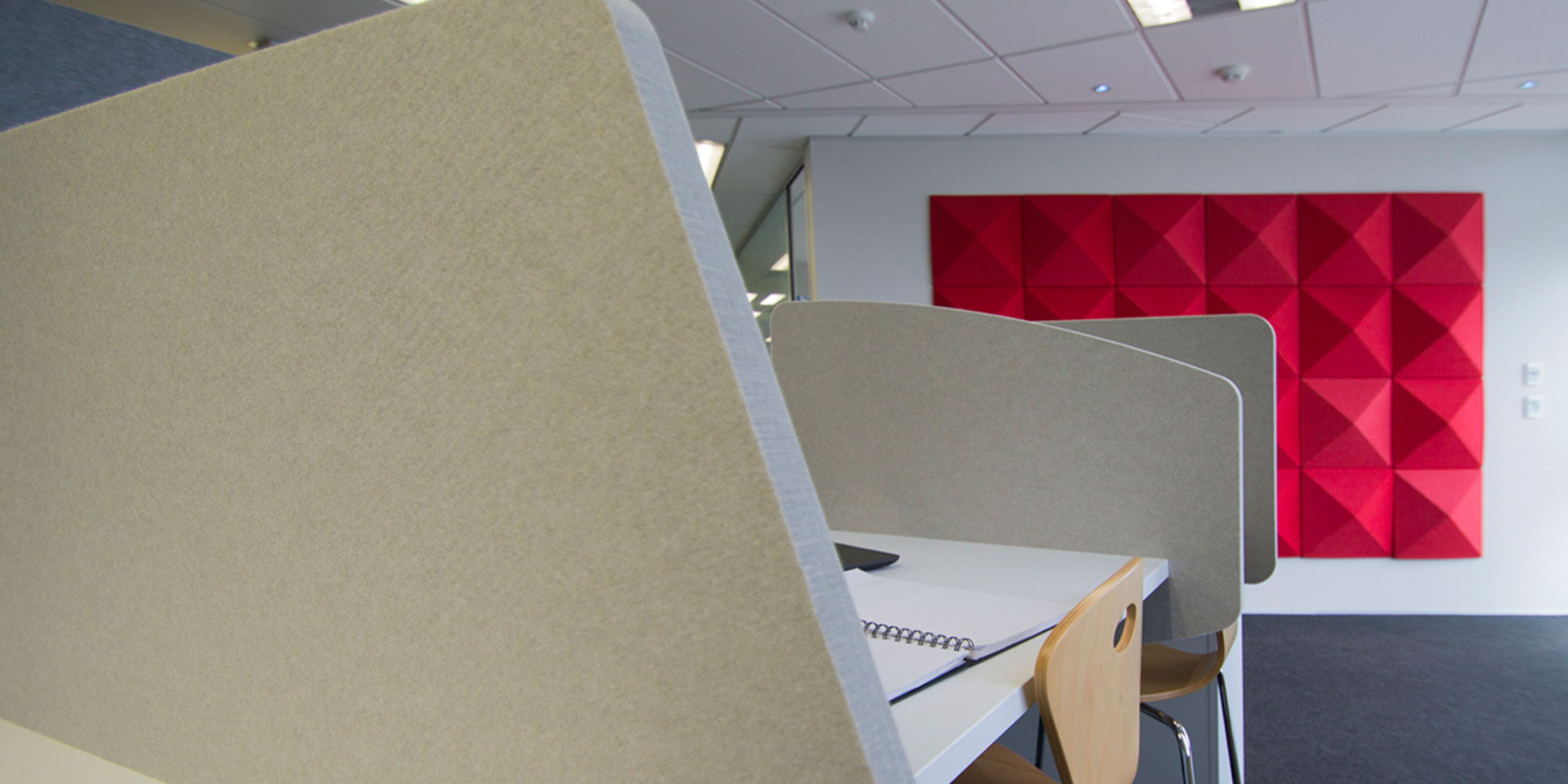 Modern office setup with black desk dividers creating private workspaces for enhanced focus and soundproofing.