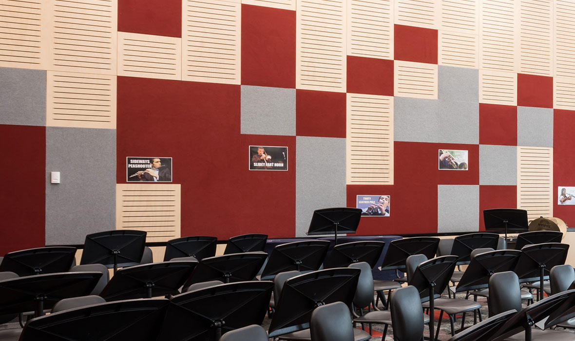 Acoustic panels enhancing sound absorption in a music classroom with red and grey Composition™ Tiles.