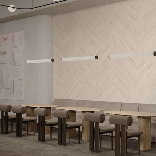 Modern café interior featuring Acoufelt WoodBeQuiet™ acoustic wall planks with herringbone design and stylish lighting.