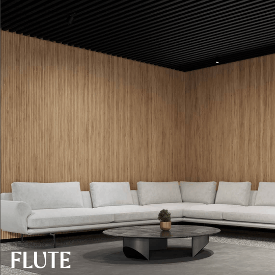 Acoufelt QuietForm 3D Debossed Acoustic Tiles "Flute" in a modern living room setting with a light gray couch.