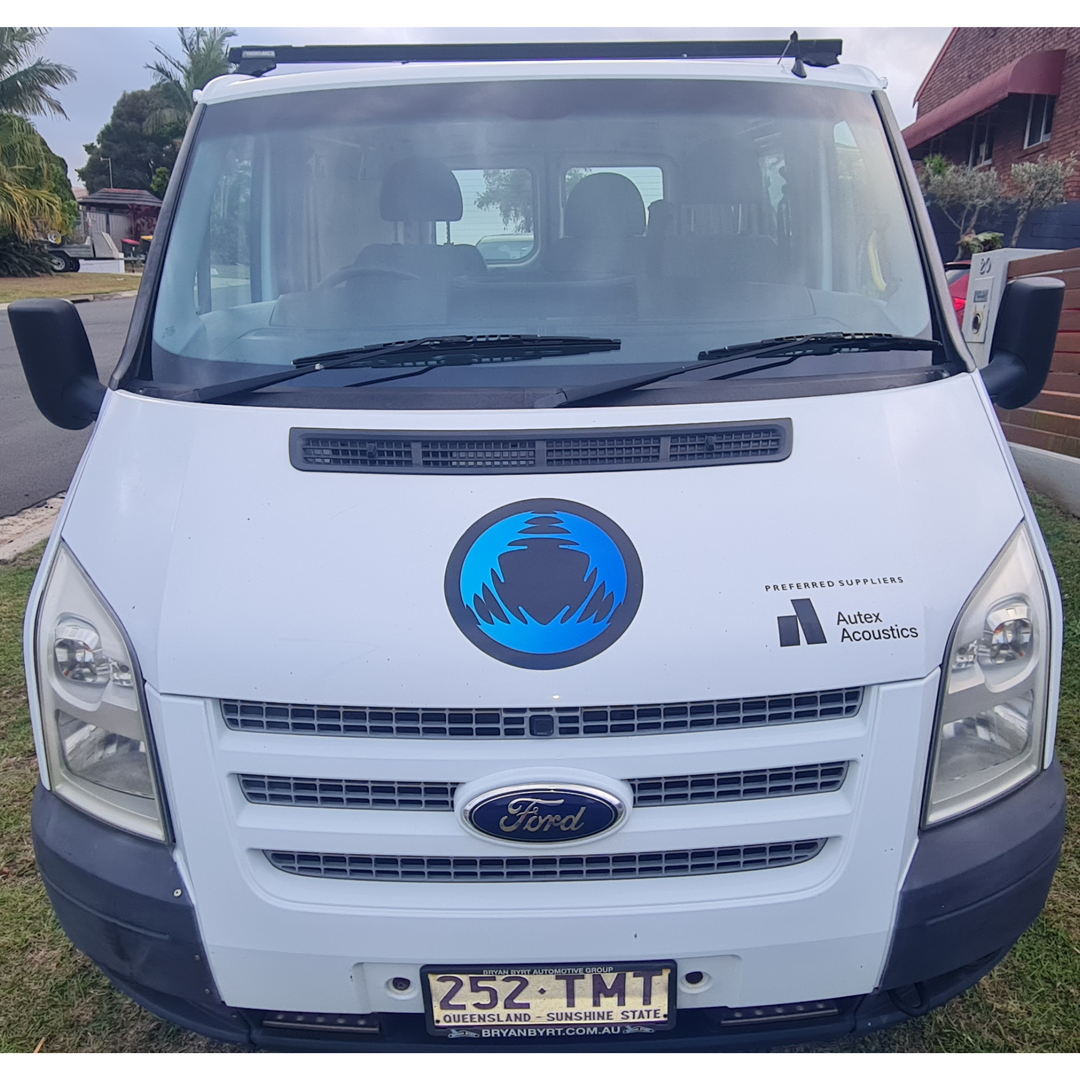 Front view of a Ford van with Autex Acoustics logo and Queensland license plate parked on a residential street.