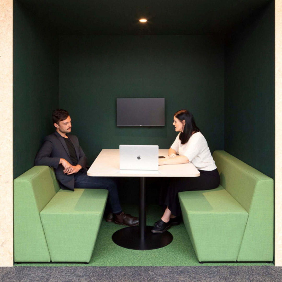 Modern meeting space featuring Autex Composition® Acoustic Panels with two people at a table and a laptop.