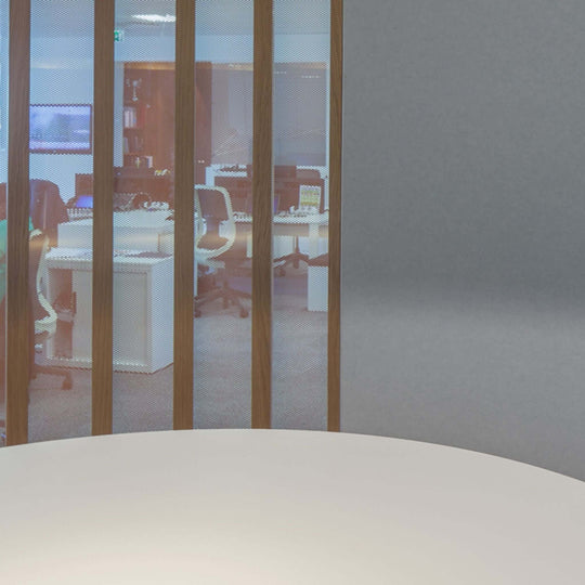 Modern office space with glass partitions and acoustic panels for enhanced sound quality and aesthetics.