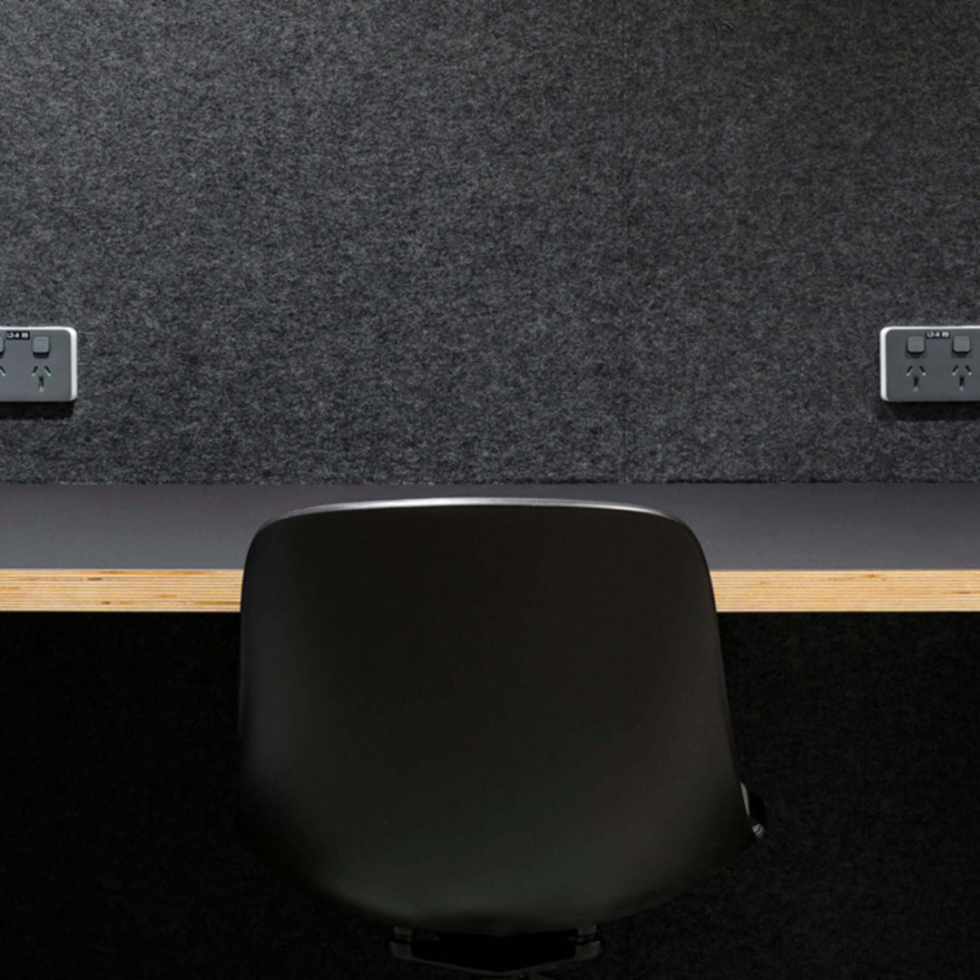 Autex Composition® Acoustic Panels on a wall in a stylish workspace with a black chair and wooden desk.