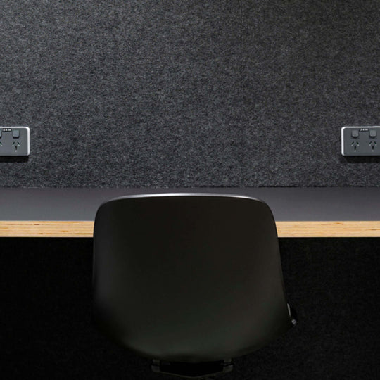 Autex Composition® Acoustic Panels on a wall in a stylish workspace with a black chair and wooden desk.