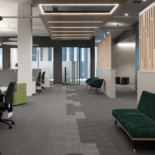 modern open-plan office featuring Autex Cove desk dividers and stylish seating for improved privacy and comfort.