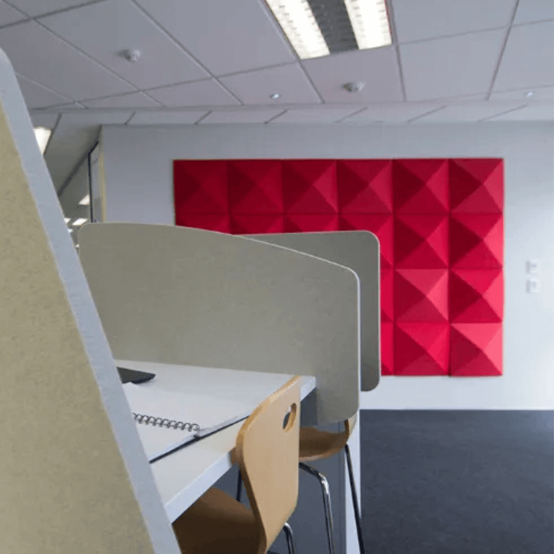 Autex Cove Desk Dividers in an open-plan office, enhancing privacy and reducing noise with a vibrant red acoustic wall panel.