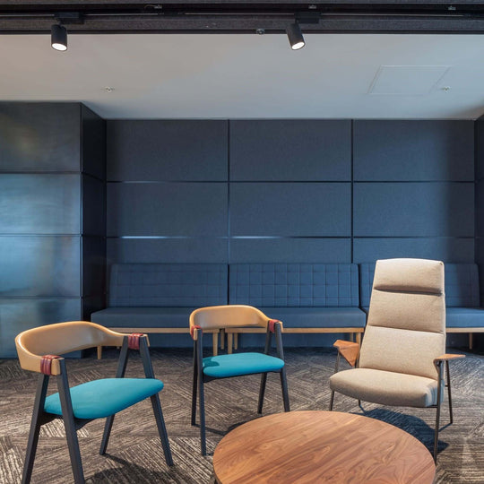 Modern interior showcasing Autex Cube™ Acoustic Panels on walls, stylish chairs, and a round wooden table.