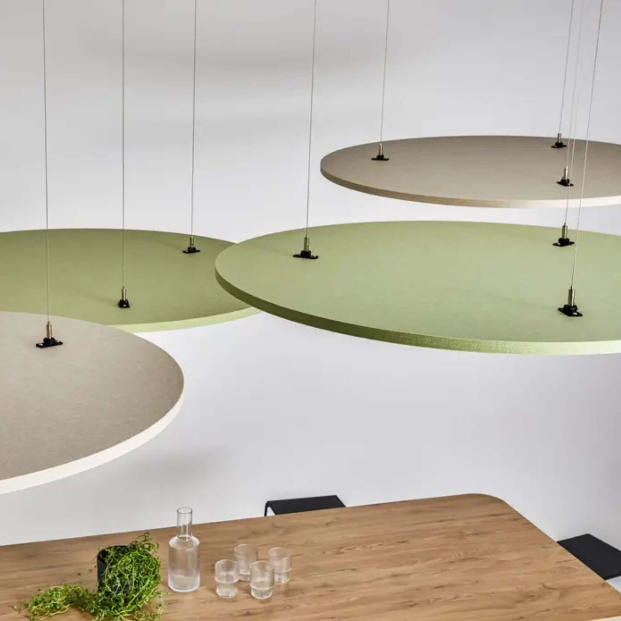 Autex Horizon Hanging Acoustics panels in green and neutral tones suspended above a wooden table, enhancing sound and style.