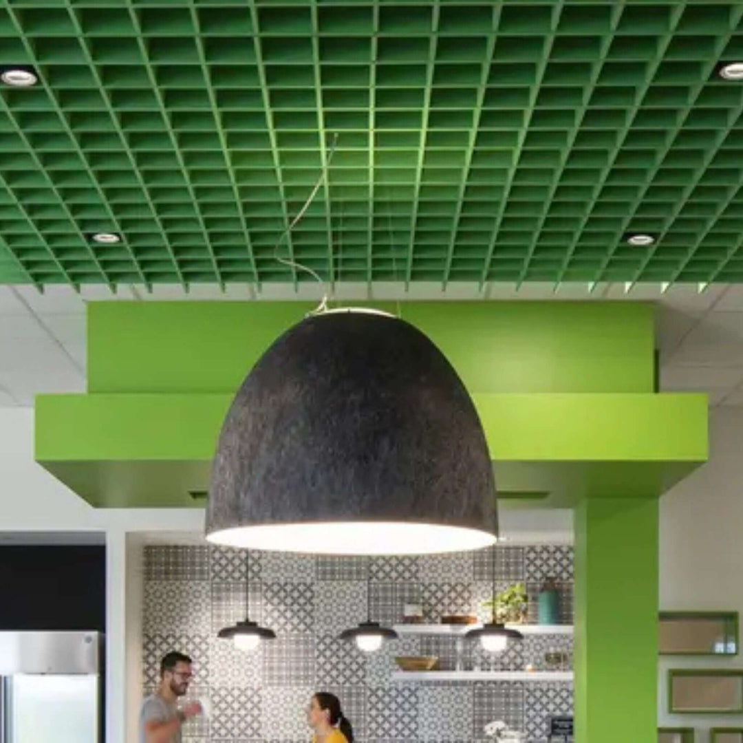 Modern workspace featuring green acoustic ceiling tiles and stylish pendant lighting for enhanced sound absorption.