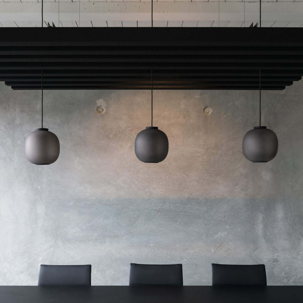 Modern interior featuring three pendant lights above a sleek table, creating a sophisticated ambiance.