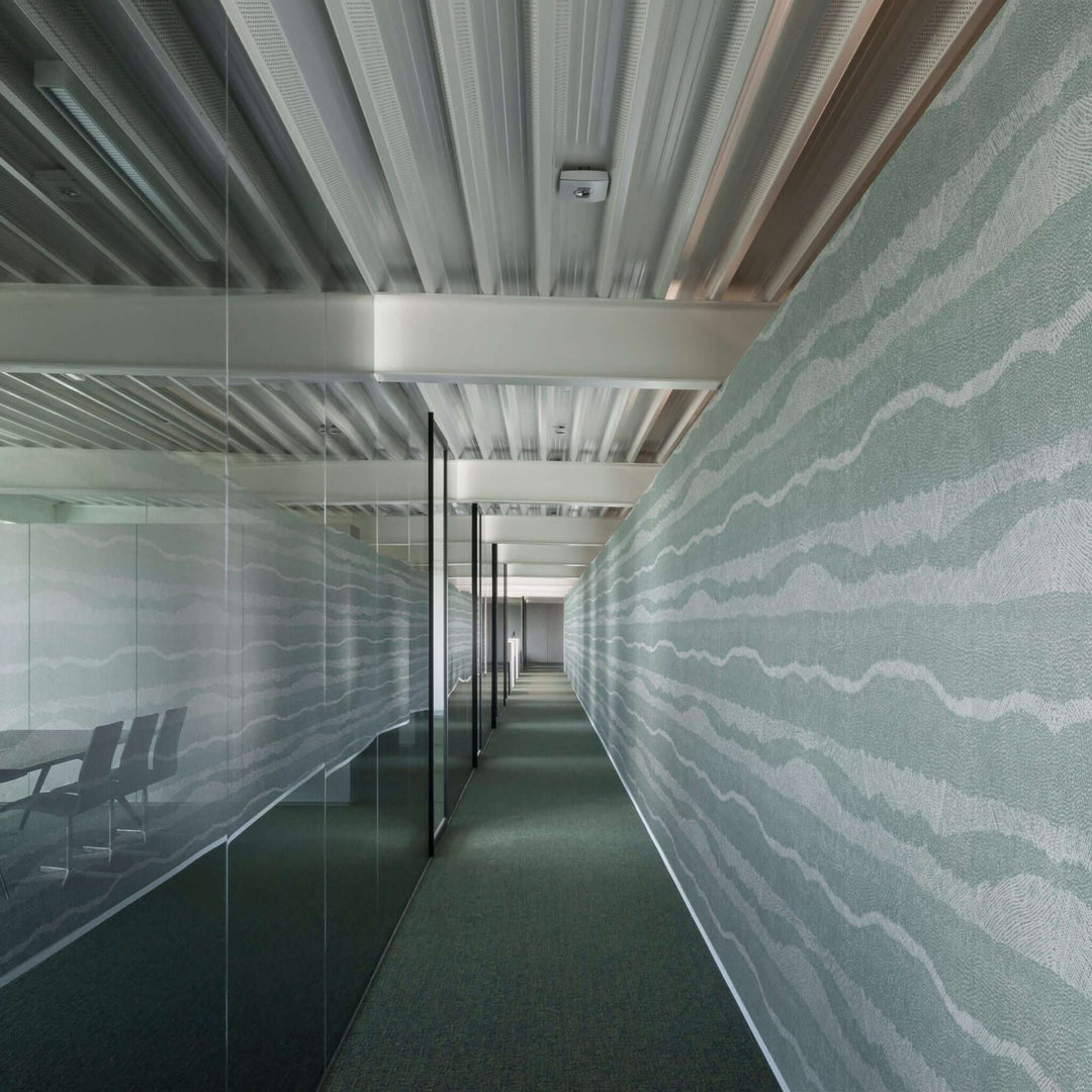 Modern office corridor featuring acoustic panels with wave patterns, enhancing sound absorption and aesthetics.