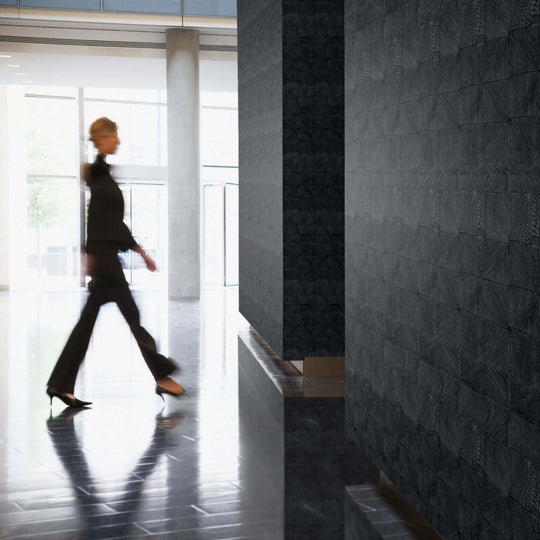 Woman walking in a modern space featuring textured acoustic panels on the walls.